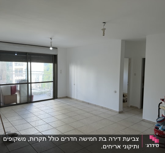 חדר ריק עם דלי צבע וכלי עבודה בפינה